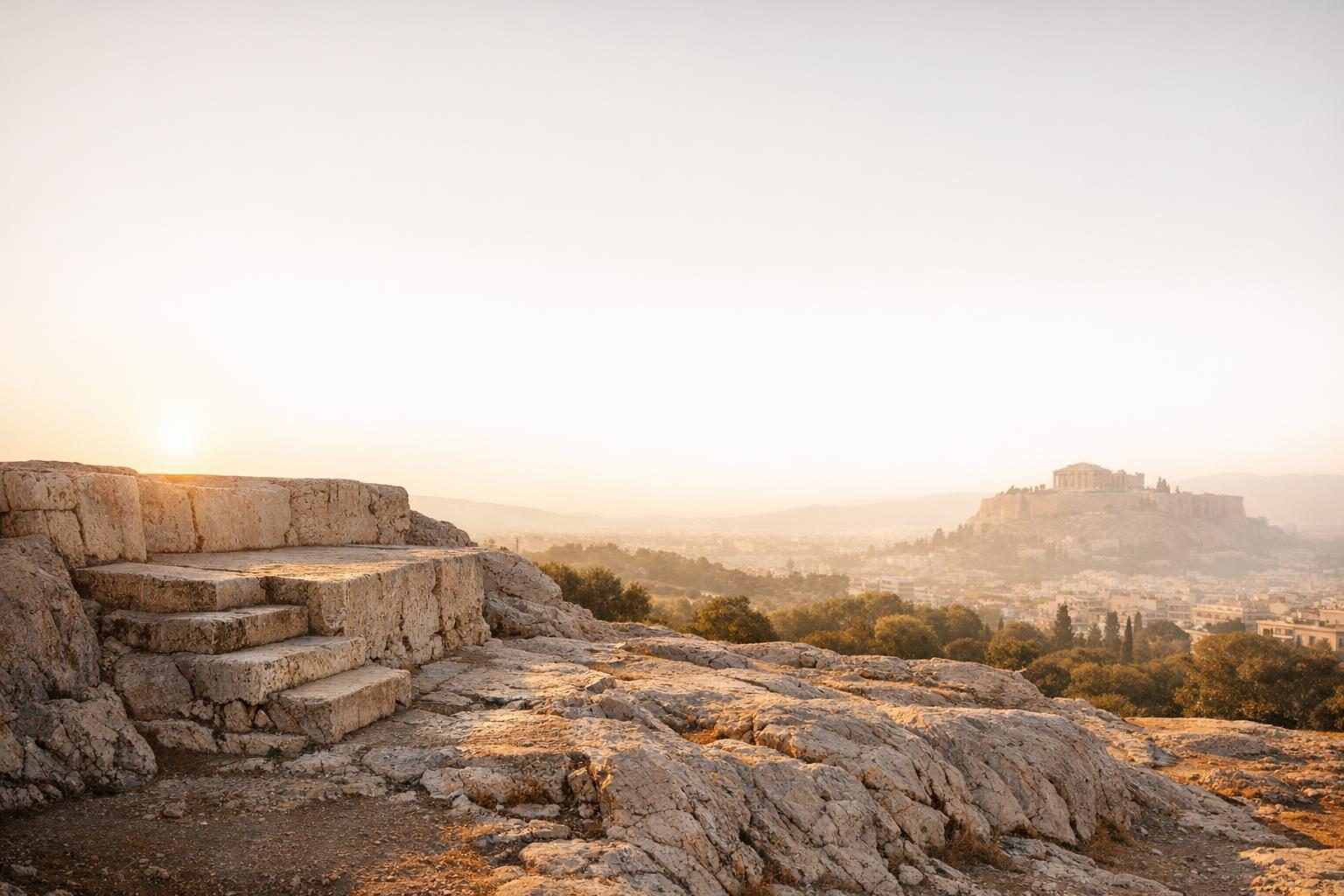 The Pnyx hill in Athens at first light, the stone speaker’s platform in the foreground and the Acropolis in the distance.